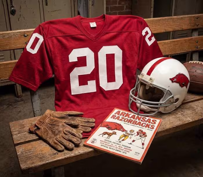 Gemini AI-created image of a 1970-era University of Arkansas American football jersey 20, without a name on it, and a matching period-correct helmet, the program cover appropriate to the era and team.