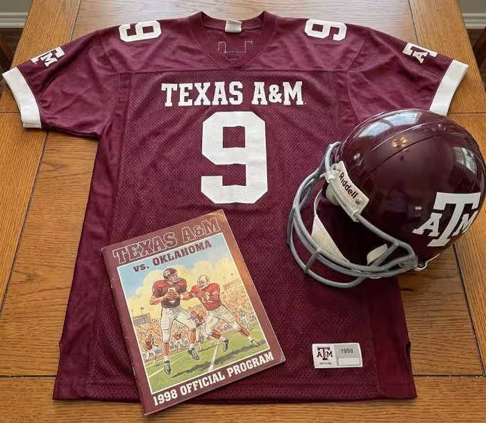 Gemini AI-created image of a 1998-era Texas A&M American football jersey 9, without a name on it, and a matching period-correct helmet, the program cover appropriate to the era and team.
