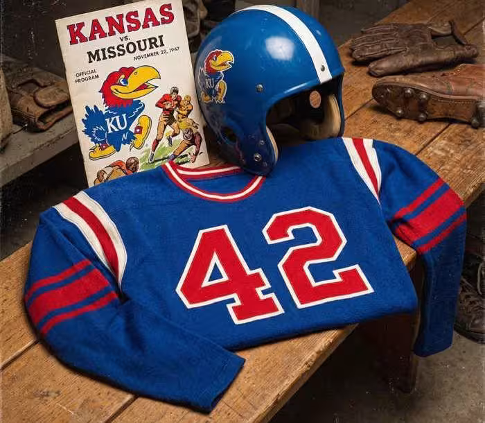 Gemini AI-created image of a 1947-era KansasAmerican football jersey 42, without a name on it, and a matching period-correct helmet, the program cover appropriate to the era and team.