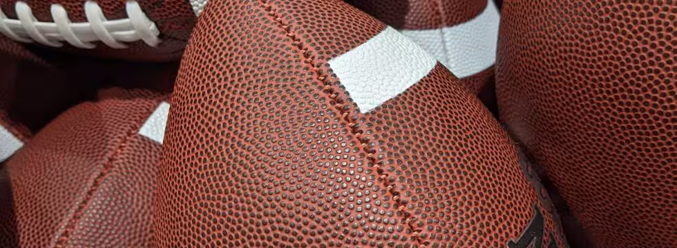 Image of many NFL Wilson Footballs in a Barrell, taken by Darin Hayes' 2021.