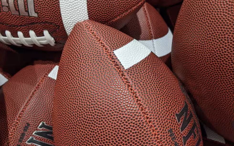 Image of many NFL Wilson Footballs in a Barrell, taken by Darin Hayes' 2021.
