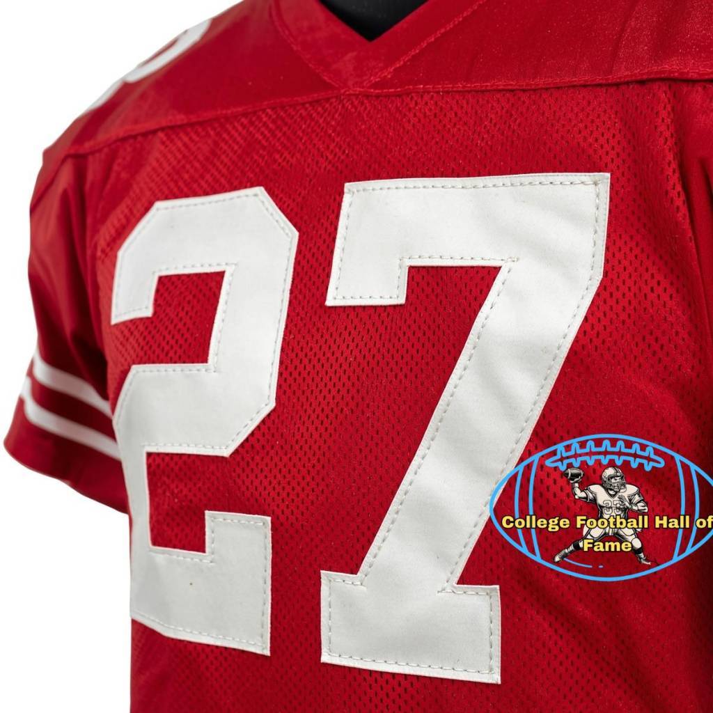 Canva AI-created of a red Ohio State jersey from the Era of Eddie George, number 27 with a Pigskin Dispatch College Football HOF seal.