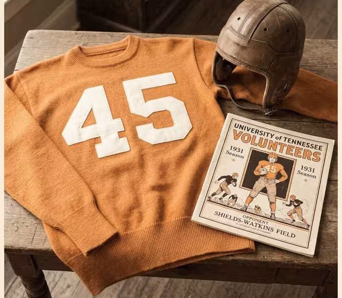 Gemini AI-created image of a 1931-era University of Tennessee American football jersey sweater 45, without a name on it, and a matching period-correct helmet, the program cover appropriate to the era and team.
