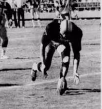 a black and white newspaper image of Dave Casper during the Holy Roller play as he leans down to scoop up the loose ball