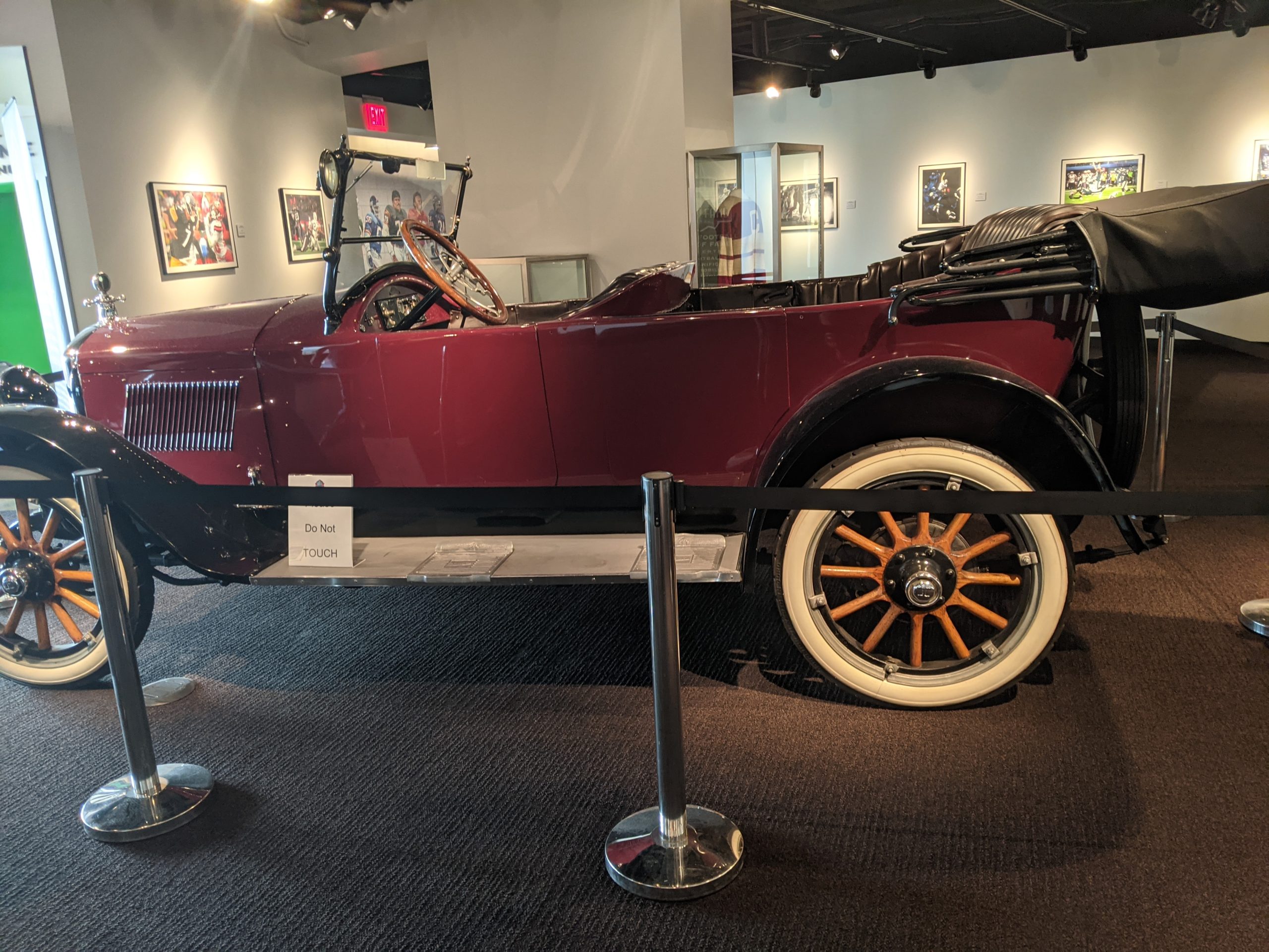 Color image of a 1921 Hupmobile convertible refurbished in dark red on display at the Pro Football HOF in Canton.