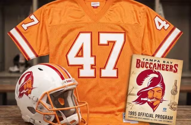 Gemini AI-created image of a 1995-era Tampa Bay NFL American football jersey 47, without a name on it, and a matching period-correct helmet, the program cover appropriate to the era and team.