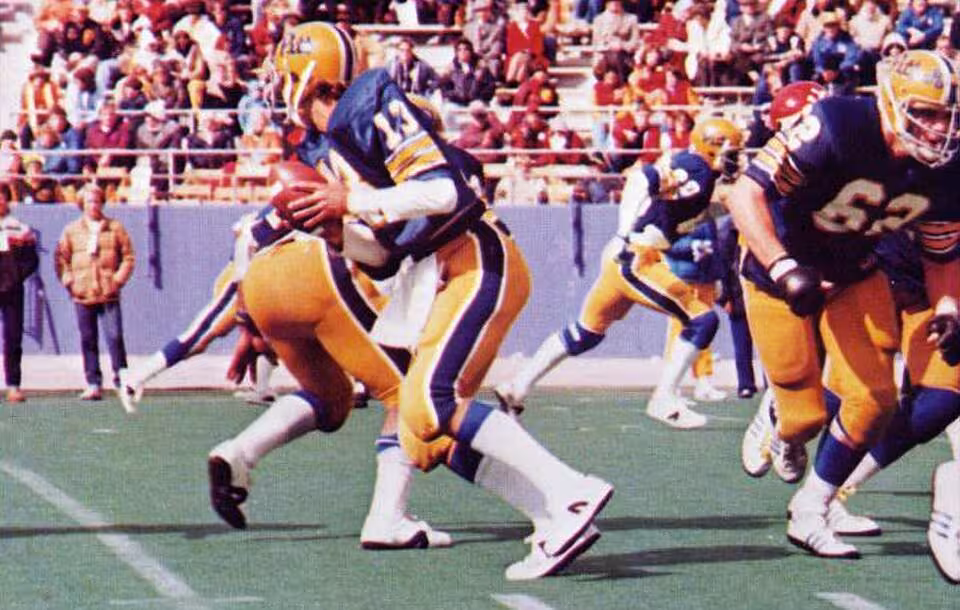 Full color game day action photo of Dan Marino quarterbacks the Pitt Panthers of the University of Pittsburgh in a football game at Pitt Stadium against the Cincinnati Bearcats on October 13, 1979. Pitt won the game 35-0.