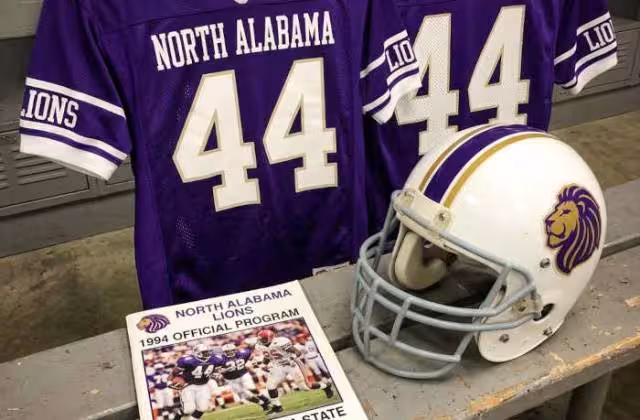 Gemini AI-created image of a 1994-era North Alabama American football jersey 44, without a name on it, and a matching period-correct helmet, the program cover appropriate to the era and team.
