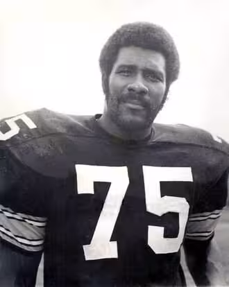 B/W image of Joe Greene #75 with Steelers in 1975.