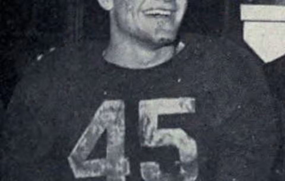 Black and white image of Photograph of Pete Elliott wearing his dark UM #45 jersey, celebrating Michigan's 1947 Big Nine championship.