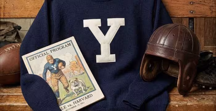 Gemini AI-created image of a 1921-era YaleAmerican football jersey sweater with a "Y" on thr front and nothing else, without a name on it, and a matching period-correct helmet, the program cover appropriate to the era and team.