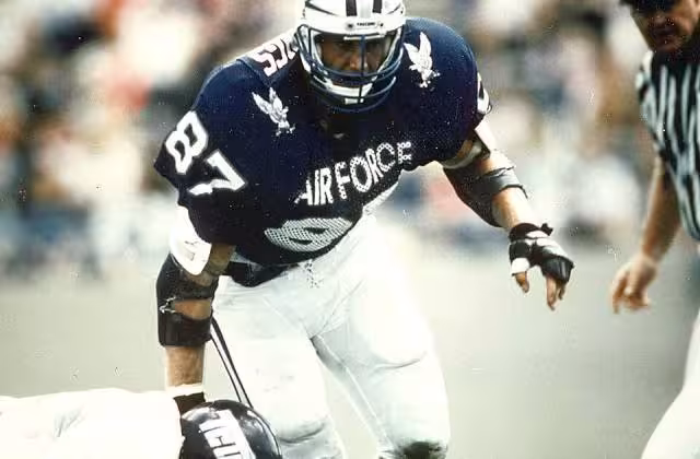 Full color game day action shot of Former Air Force great Chad Hennings, a 1988 graduate of the Air Force Academy, was elected to the College Football Hall of Fame on May 16, 2006. He was considered one of college football's great defensive linemen of his era, a unanimous first-team All-America selection in 1987 who received the Outland Trophy as the nation's top interior lineman. As a pro, he embarked on a nine-year NFL career with the Dallas Cowboys that brought him three Super Bowl titles. (U.S. Air Force photo).
