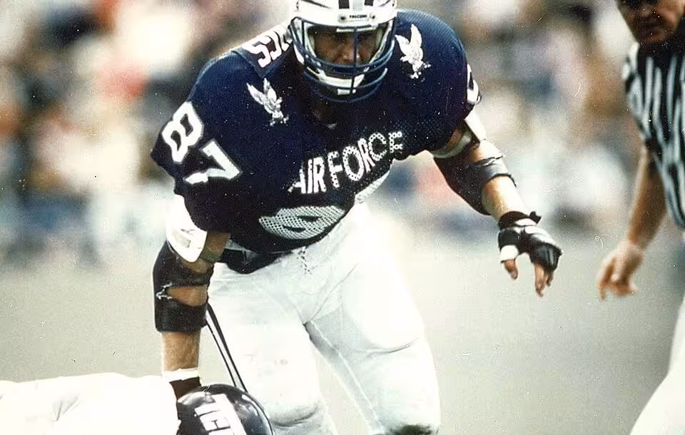 Full color game day action shot of Former Air Force great Chad Hennings, a 1988 graduate of the Air Force Academy, was elected to the College Football Hall of Fame on May 16, 2006. He was considered one of college football's great defensive linemen of his era, a unanimous first-team All-America selection in 1987 who received the Outland Trophy as the nation's top interior lineman. As a pro, he embarked on a nine-year NFL career with the Dallas Cowboys that brought him three Super Bowl titles. (U.S. Air Force photo).