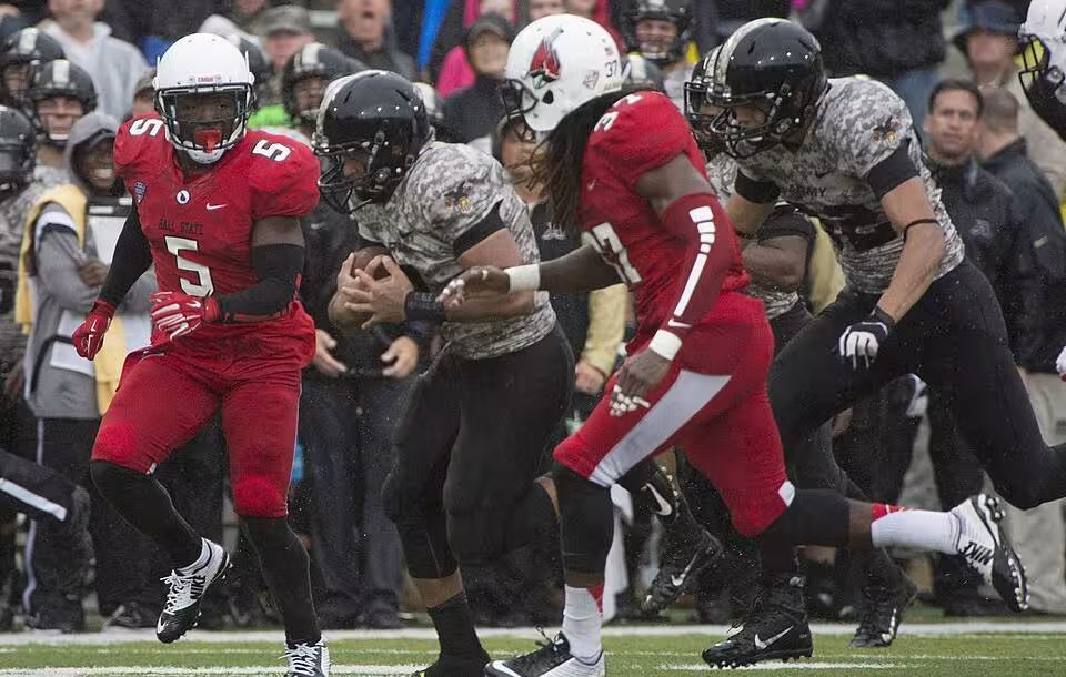 full color game action shot in 2014, A football game between Army and Ball State in 2014. Taken by John Pellino via Wikimedia Commons.