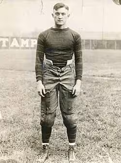 Vintage, B/W full body publicity pose of Tom Davies in 1921, in full Pitt football uniform.