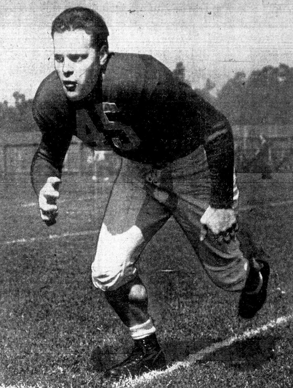 b/w newspaper image of an action shot publicity photo of American football player Chuck Taylor in 1942