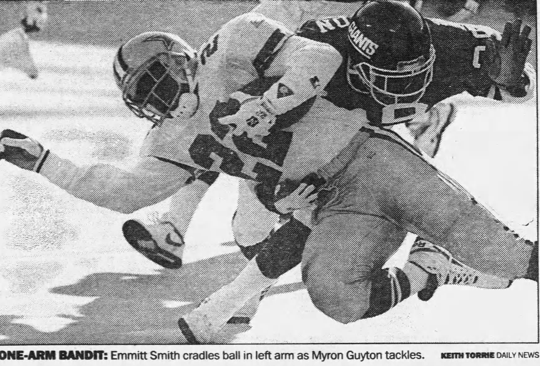Black and white newspaper image of Emmitt Smith diving for extra yardage in his Dallas uniform