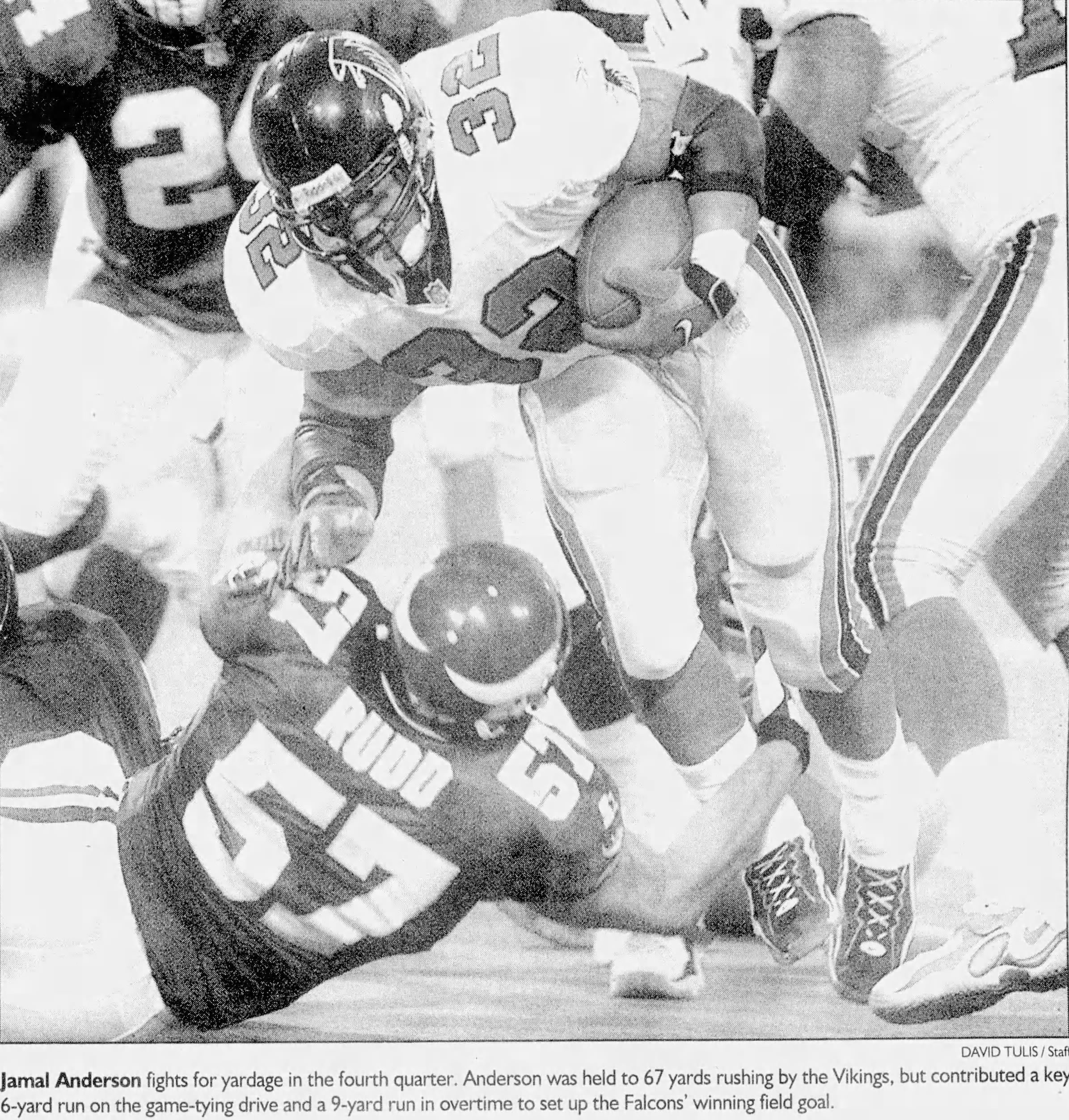 A black-and-white newspaper action photo of Atlanta Falcons running back Jamal Anderson (#32) fighting for yardage against the Minnesota Vikings. Anderson is shown leaning forward, clutching the football, as Vikings linebacker Dwayne Rudd (#57) attempts a low tackle. The caption notes that Anderson was held to 67 rushing yards but contributed a key 16-yard run on the game-tying drive and a 9-yard run in overtime to set up the winning field goal.