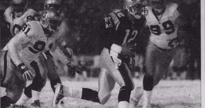 black and white newspaper image of Patriots QB Tom Brady scrambling away from Oakland defenders in the snow of the famous Tuck Rule play in 2002