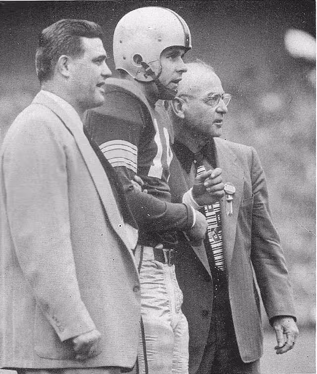 black and white game sideline image of Photograph of Ohio State football coach Woody Hayes with fullback Dick Doyle and assistant coach Ernie Godfrey, 1952.