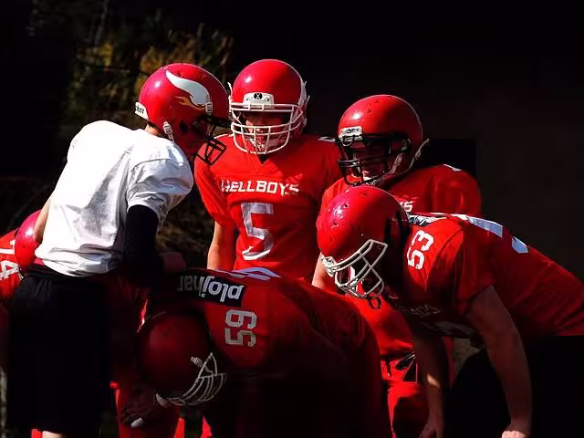 image of red clad gridiron players in a practice time huddle