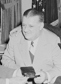 Black and white image of a cropped Bert Bell sitting at a table