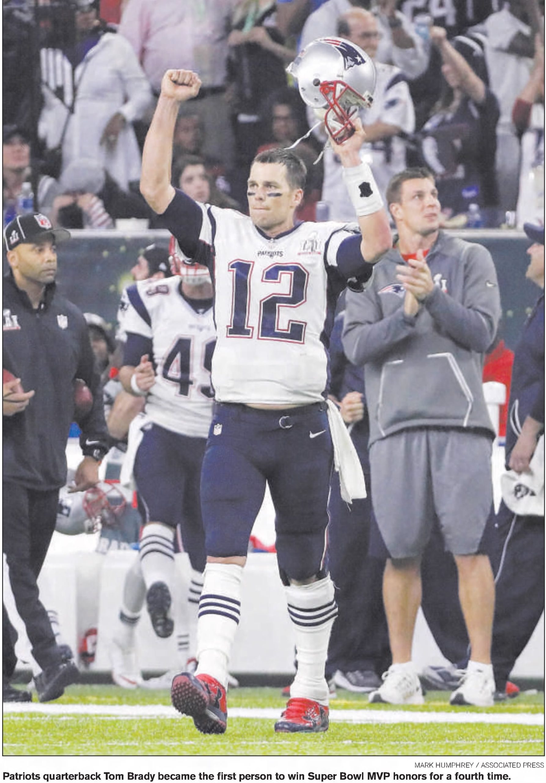 Color AP newspaper image of Tom Brady raising his hands in victory in his white New England Patriots number 12 uniform