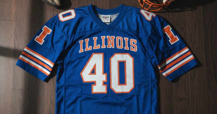 Image of a blue Illinois football Jersey number 40 with a football helmet and old cleats.