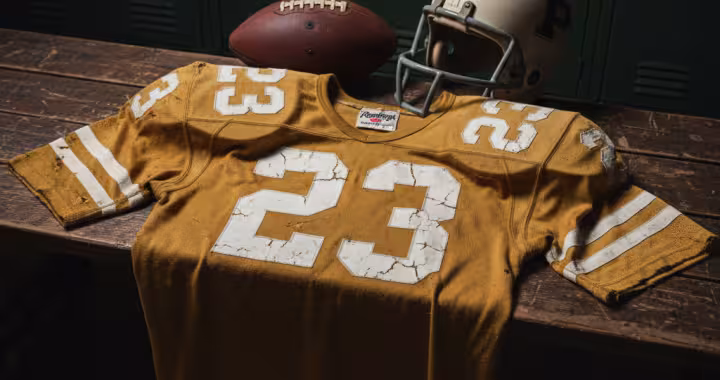 Image of an orange football Jersey number 23 with a football helmet and ball.