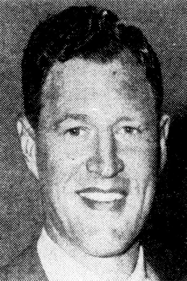 A black-and-white headshot of Nebraska football standout Bobby Reynolds from 1950. The high-contrast, newsprint-style photograph shows Reynolds smiling, with dark, neatly parted hair. He is wearing a light-colored collared shirt under a dark jacket. The image has a visible halftone dot pattern, typical of archival newspaper or yearbook reproductions from the mid-20th century.