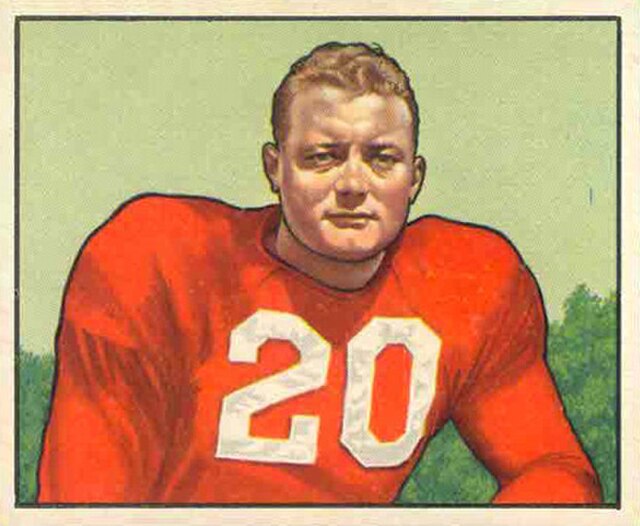 A vintage 1950 Bowman football card of Buster Ramsey. The colorized illustration shows Ramsey from the chest up, wearing a bright red jersey with the number '20' in white block digits. He has a serious expression and short, reddish-blonde hair, set against a simple light green background.