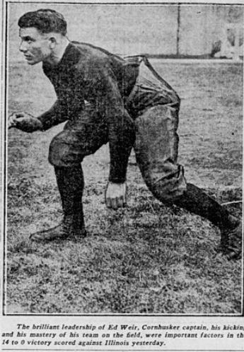 A vintage black-and-white newspaper photograph of Ed Weir, captain of the Nebraska Cornhuskers, in a football three-point stance on a grass field. He is wearing a dark, long-sleeved jersey and high-top cleats. Captioned text below the image credits his leadership and mastery in a 14 to 0 victory against Illinois.