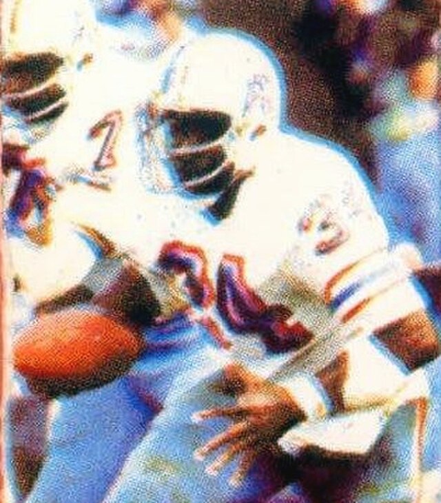 A close-up, grainier crop from a 1981 NFL ticket stub featuring the Houston Oilers and the Pittsburgh Steelers. The illustration shows a player in the classic 'Luv Ya Blue' white Oilers jersey with light blue and red accents. He is wearing a white helmet with a dark facemask, braced for contact on a bright afternoon. The textured, dotted print of the original ticket is clearly visible, giving it an authentic vintage feel.