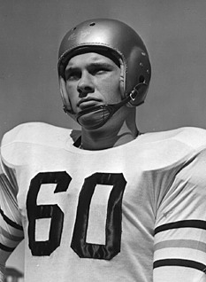 A black-and-white studio portrait of Hall of Fame guard Ray Beck from Georgia Tech. He is wearing a white jersey with the number '60' in dark block digits and sleeve stripes. He is equipped with a smooth, silver-colored suspension helmet with a leather chin strap, looking upward with a determined expression.