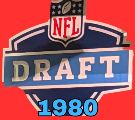 NFL Draft sign in color on a reddish background with the year 1980 text across the bottom in blue. The original cropped image was taken by Darin Hayes at AT&T Stadium in 2022.