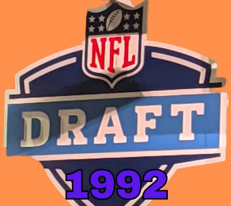 NFL Draft sign in color on a orange background with the year 1992 text across the bottom in blue. The original cropped image was taken by Darin Hayes at AT&T Stadium in 2022.