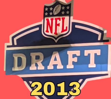 NFL Draft sign in color on a reddish background with the year 2013 text across the bottom in bright yellow. The original cropped image was taken by Darin Hayes at AT&T Stadium in 2022.