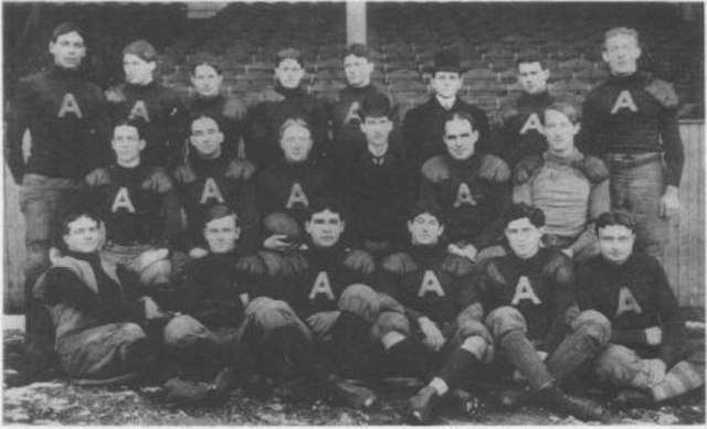 Archival 1902 Philadelphia Athletics football team portrait. Black and white photo of players in dark wool sweaters with a large white 'A' and quilted canvas trousers. Features Hall of Fame manager Connie Mack's professional football squad for historical sports research and Pigskin Dispatch archives.