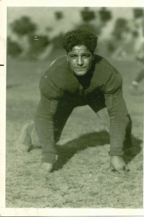 Vintage black and white image of Ed Franco in his Fordham uniform in a four point stance publicty pose.