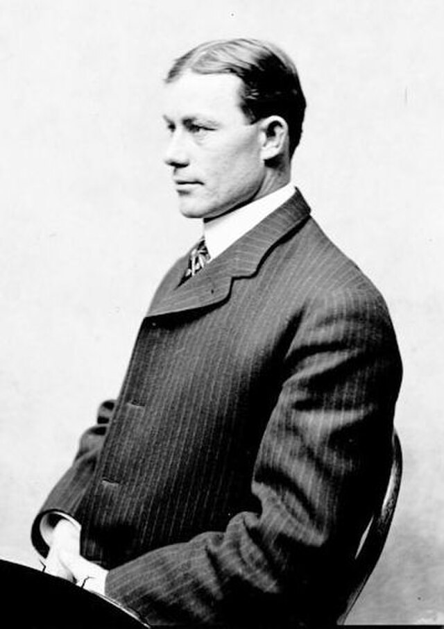 Vintage side-profile portrait of Michigan football coach Fielding H. 'Hurry Up' Yost. Black and white archival image showing Yost in a pinstripe suit and high collar, representing the 'Point-a-Minute' era of historical collegiate sports research and Pigskin Dispatch archives.