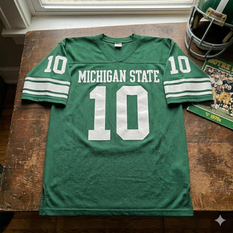 Vintage-style Michigan State #10 jersey display with a 1970s game program and a classic Spartan green Riddell helmet.
