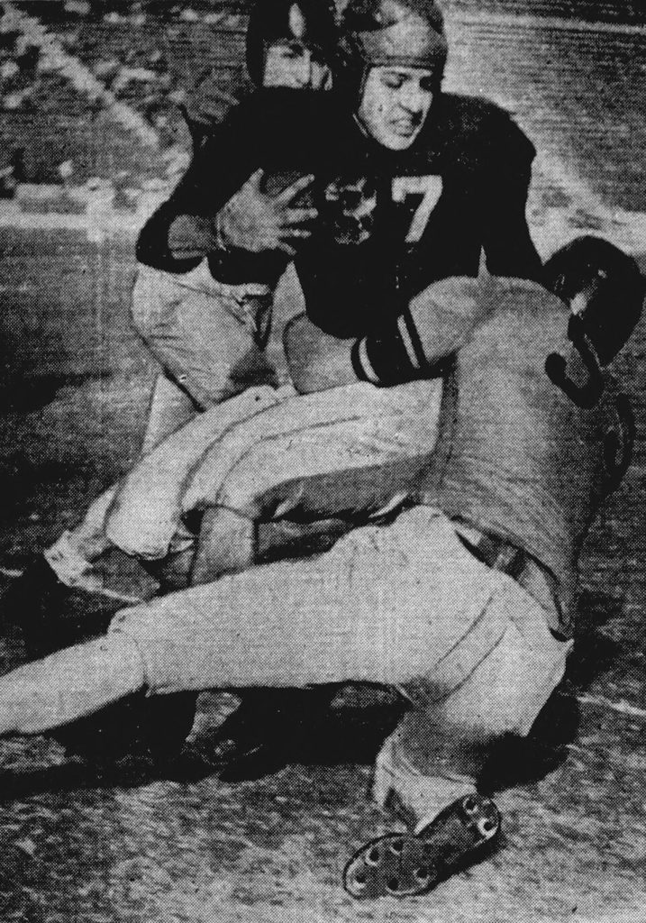 Vintage black and white game action photo of USC Trojans football player Terry Ragan is brought down by Oregon State Beavers defender Leonard Rinearson during a game November 24, 1945 at the Los Angeles Memorial Coliseum in Los Angeles, California.