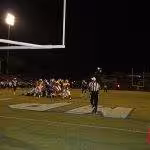 Color image of action at a high school football game.