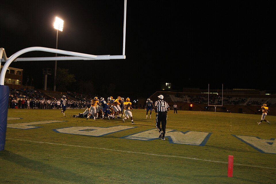 Color image of action at a high school football game.