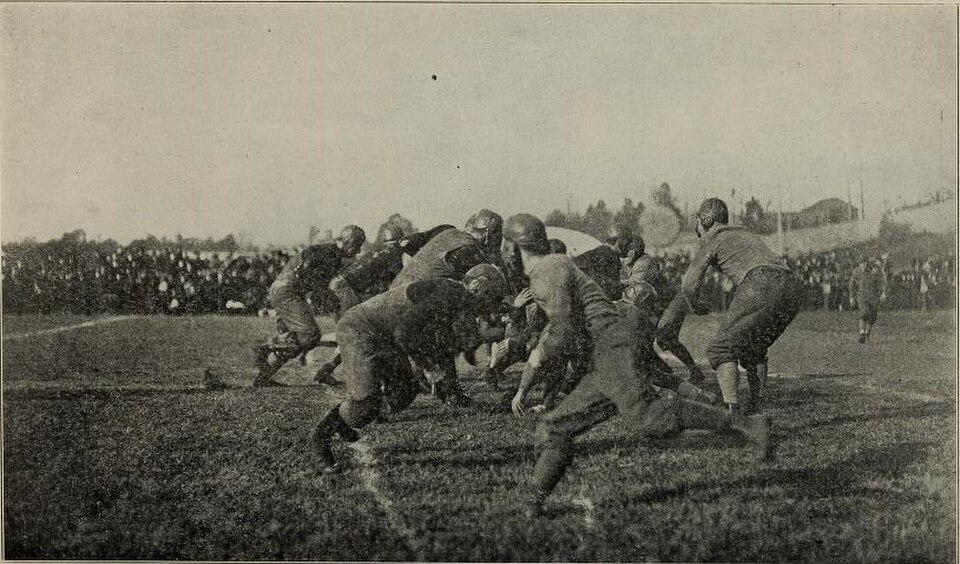 black and white vintage game action photo of A scene from an unknown football game featuring the 1912 Georgia Tech Yellow Jackets. The caption reads, "An exciting moment in one of the most important foot ball games".