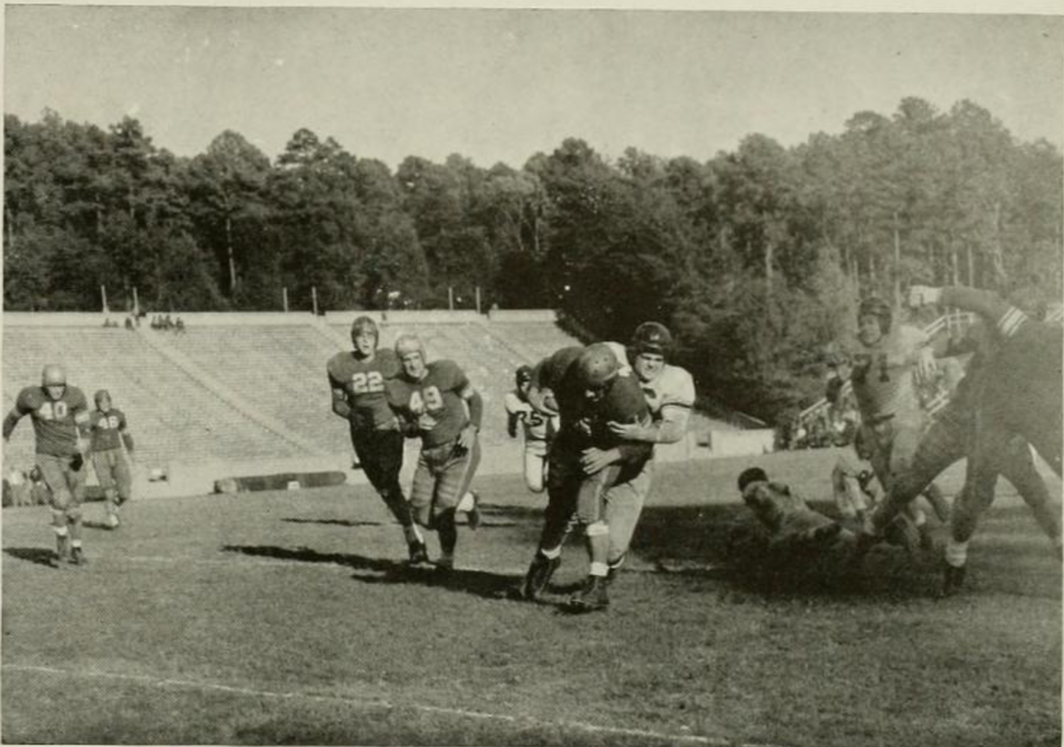 Vintage, black and white, game action photo of Scene from a college football game between the North Carolina Tar Heels and the William & Mary Indians at Kenan Memorial Stadium, November 11, 1944. Caption reads "Smith stops and Indian for no gain".