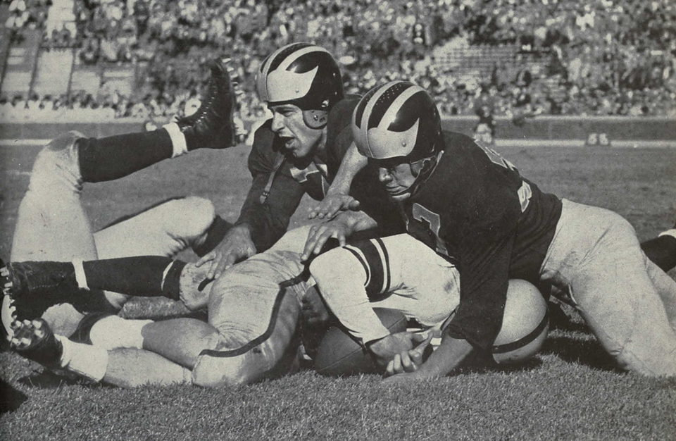 Vintage black and white game action photo of 1952 Michigan football players.