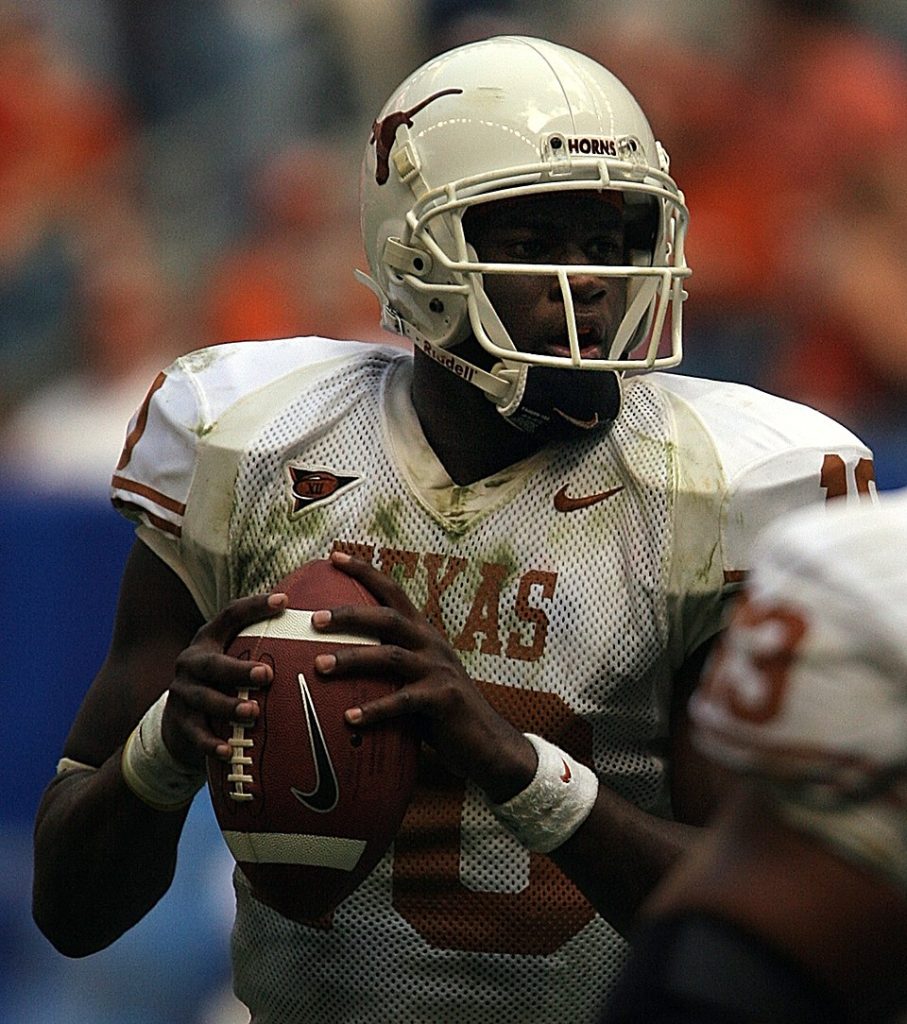 Color game action photo of Texas QB Vince Young back to pass, wearing the all white Longhorns uniform.