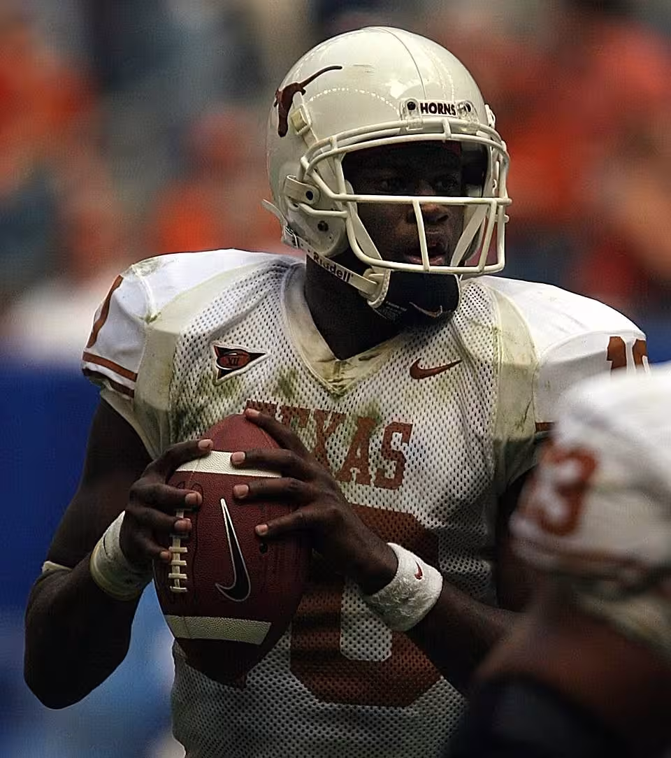 Color game action photo of Texas QB Vince Young back to pass, wearing the all white Longhorns uniform.