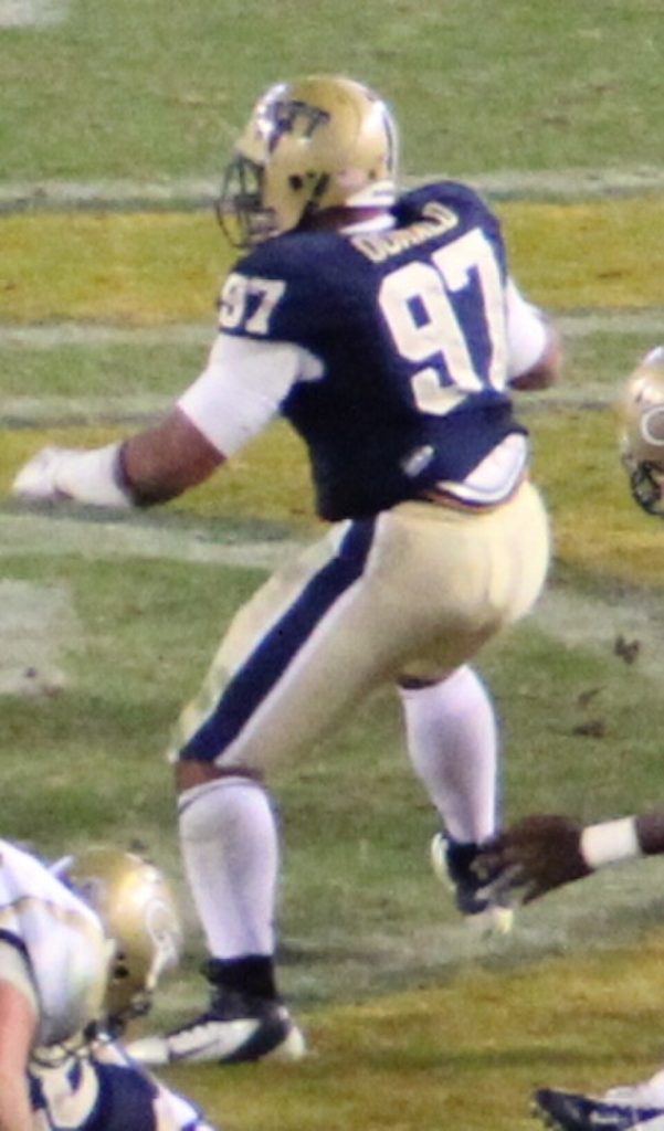 Color game day action of Pitt Panther defender Aaron Donald in 2013 wearing the home dark jersey number 97, getting in position to make a play.